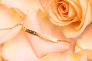 Product photography Gold I Am Worthy Necklace By Jenna Kutcher on a bed of pink rose petals